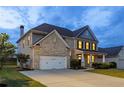 Beautiful two-story home with a two-car garage and well-maintained landscaping at dusk at 1261 Palouse Hills Pl, Lawrenceville, GA 30044