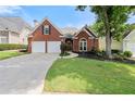 Beautiful brick home with a well-maintained lawn, mature trees, and a two-car garage at 1805 Wilkenson Xing, Marietta, GA 30066