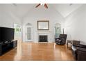 Open living room featuring hardwood floors, a fireplace, and plenty of natural light from large windows at 1805 Wilkenson Xing, Marietta, GA 30066
