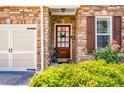 Close-up of the front door with brick surround, decorative wreath, and manicured shrubs at 1024 Brownstone Dr # 2, Marietta, GA 30008