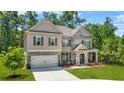 Beautiful two-story home with a mix of brick and siding, a two-car garage, and lush landscaping at 625 St Annes Pl, Covington, GA 30016