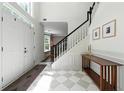 Bright foyer with a patterned tile floor, staircase, and decorative console table at 312 Laurel Run Cv, Sugar Hill, GA 30518