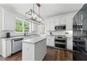 Modern kitchen with white cabinets, stainless steel appliances, and a center island at 312 Laurel Run Cv, Sugar Hill, GA 30518