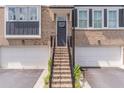 Brick townhouse with a staircase leading to the front door above two car garage spaces at 370 Thrasher St # 5, Norcross, GA 30071