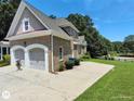 Side view of the house showing the two-car garage, driveway, and well-maintained lawn at 1292 Hidden Spirit Trl, Lawrenceville, GA 30045