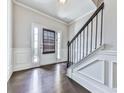 Elegant foyer with dark hardwood floors, white trim, and a staircase with black metal railing at 212 Torch Dr, Acworth, GA 30102