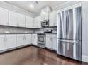 Modern kitchen featuring white cabinets, stainless steel appliances, granite countertops, and dark hardwood floors at 212 Torch Dr, Acworth, GA 30102