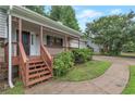 Inviting front porch with wooden supports and steps, surrounded by lush greenery at 1240 Rocky Rd, Lawrenceville, GA 30044