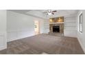 Cozy living room with a stone fireplace, built-in bookshelves, and neutral carpet at 1240 Rocky Rd, Lawrenceville, GA 30044