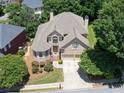 Stunning aerial view of a well-maintained brick home with lush landscaping and mature trees in a serene neighborhood at 2002 Ivy Ridge Se Rd, Smyrna, GA 30080