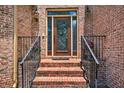 Elegant front door with glass detailing, brick steps, and decorative iron railings for a welcoming entrance at 2002 Ivy Ridge Se Rd, Smyrna, GA 30080