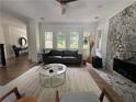 Bright living room with decorative fireplace, large windows, hardwood floors, and stylish furniture at 2088 Emery Ne Pl, Atlanta, GA 30317
