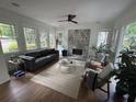 Bright living room with decorative fireplace, large windows, hardwood floors, and stylish furniture at 2088 Emery Ne Pl, Atlanta, GA 30317