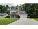 Charming two-story home featuring a well-manicured lawn and a two-car garage at 2161 Denson Sw Ln, Marietta, GA 30008