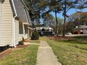 Exterior side view of a two-story home with a sidewalk, neutral siding, tidy landscaping, and mature trees at 4383 Idlewood Ln, Tucker, GA 30084