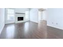 Bright living room with dark wood floors, a white brick fireplace, and multiple windows for natural light at 4383 Idlewood Ln, Tucker, GA 30084