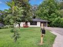 Landscaped front yard leading to a charming single-story home with painted brick at 5207 White Sw Blvd, Mableton, GA 30126