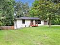 Single-story home with painted brick, a cozy front porch, and a well-maintained lawn at 5207 White Sw Blvd, Mableton, GA 30126