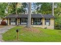 Charming single-story home with a well-maintained lawn, traditional windows and black shutters at 761 Robert E Lee Pkwy, Jonesboro, GA 30238