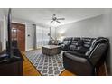 Inviting living room featuring a comfortable leather sofa, ceiling fan, and a decorative area rug at 761 Robert E Lee Pkwy, Jonesboro, GA 30238