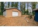 View of the detached garage in the backyard with a white door and fallen leaves at 1089 Indale Sw Pl, Atlanta, GA 30310