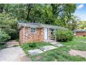 Brick house featuring a small porch with stone steps surrounded by lush foliage at 1279 Kenilworth Sw Dr, Atlanta, GA 30310