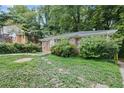 Charming brick home with stone walkway, surrounded by mature trees and greenery at 1279 Kenilworth Sw Dr, Atlanta, GA 30310