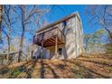 Home's rear exterior featuring a raised wooden deck and a backyard surrounded by trees at 169 Holly Ct, Loganville, GA 30052