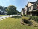 Side view of two-story brick home with red shutters, covered front porch, manicured lawn and landscaping at 3139 Tuscan Ridge Dr, Snellville, GA 30039