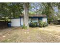 View of a white house with blue trim, surrounded by trees and a lawn, creating a serene, private setting at 1321 Mcclelland Ave, Atlanta, GA 30344