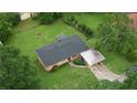 Aerial view of a cozy home with a well-maintained lawn, carport, and mature trees at 1342 Peggy Nw Ln, Conyers, GA 30012