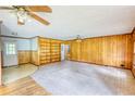 Cozy living room with wood paneling, a built-in bookshelf, and dual ceiling fans at 1342 Peggy Nw Ln, Conyers, GA 30012