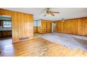 Spacious living room with wood paneling, built-in shelves, and ceiling fans at 1342 Peggy Nw Ln, Conyers, GA 30012