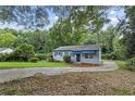 A quaint single-story house with a paved driveway and mature trees surrounding the property at 2436 Clarissa Nw Dr, Atlanta, GA 30318