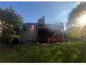 Back of a two-story home with a large back deck, American flag, yard swing, trees and a blue sky at 2580 Three Wood Dr, Villa Rica, GA 30180