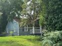 Charming blue cottage style home with a fenced yard surrounded by mature trees at 1417 Graymont Sw Dr, Atlanta, GA 30310