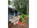 Exterior view showcasing the front porch, blue shutters, and lush greenery of this cozy home at 3530 Fairlane Nw Dr, Atlanta, GA 30331