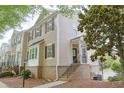Traditional townhome featuring brick accents, dark shutters, and a quaint covered entryway with stairs at 3761 Lake Point Blvd, Suwanee, GA 30024