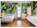 Inviting bedroom with lush tropical wallpaper, hardwood floors, and a sun-filled ambiance at 200 B Reinhardt Se St, Atlanta, GA 30312