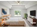Staged main bedroom with tray ceilings, neutral palette, large windows and ensuite bath at 2226 Exchange Se Pl, Conyers, GA 30013