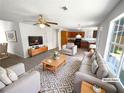 Staged living room featuring neutral furniture, a ceiling fan, and an open layout leading to the kitchen at 509 Carlton Pointe Dr, Palmetto, GA 30268
