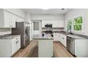 Modern kitchen with stainless steel appliances, granite countertops, a kitchen island, and wood-look floors at 1931 Abinger Way, Lawrenceville, GA 30043