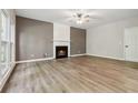 Spacious living room featuring wood floors, a fireplace with a mantel, and natural light from a large window at 1931 Abinger Way, Lawrenceville, GA 30043