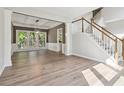 Bright living room showcasing wood floors, large windows offering natural light, and staircase with wood railings at 1931 Abinger Way, Lawrenceville, GA 30043