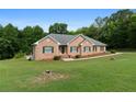 Brick home featuring a well-manicured lawn and green shutters at 604 Clearwater Ct, Mcdonough, GA 30252