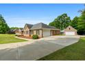 Brick home with a spacious driveway leading to a detached garage at 604 Clearwater Ct, Mcdonough, GA 30252
