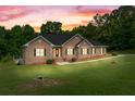 Dusk view of a brick home with green lawn at 604 Clearwater Ct, Mcdonough, GA 30252