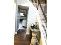 Inviting foyer with hardwood floors, staircase, decorative table with photos, and a glimpse of the living room beyond at 6265 Lake Windsor Pkwy, Buford, GA 30518