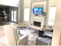 Bright living room with tall windows, fireplace, TV, and a view into the kitchen, perfect for entertaining at 6265 Lake Windsor Pkwy, Buford, GA 30518
