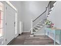 Bright entryway with hardwood floors and staircase with white risers and black metal railings at 3735 Turnbury Oaks Dr, Peachtree Corners, GA 30096